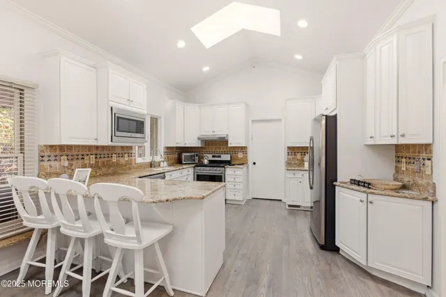 a dining hall with stainless steel appliances granite countertop a granite counter tops and a large window