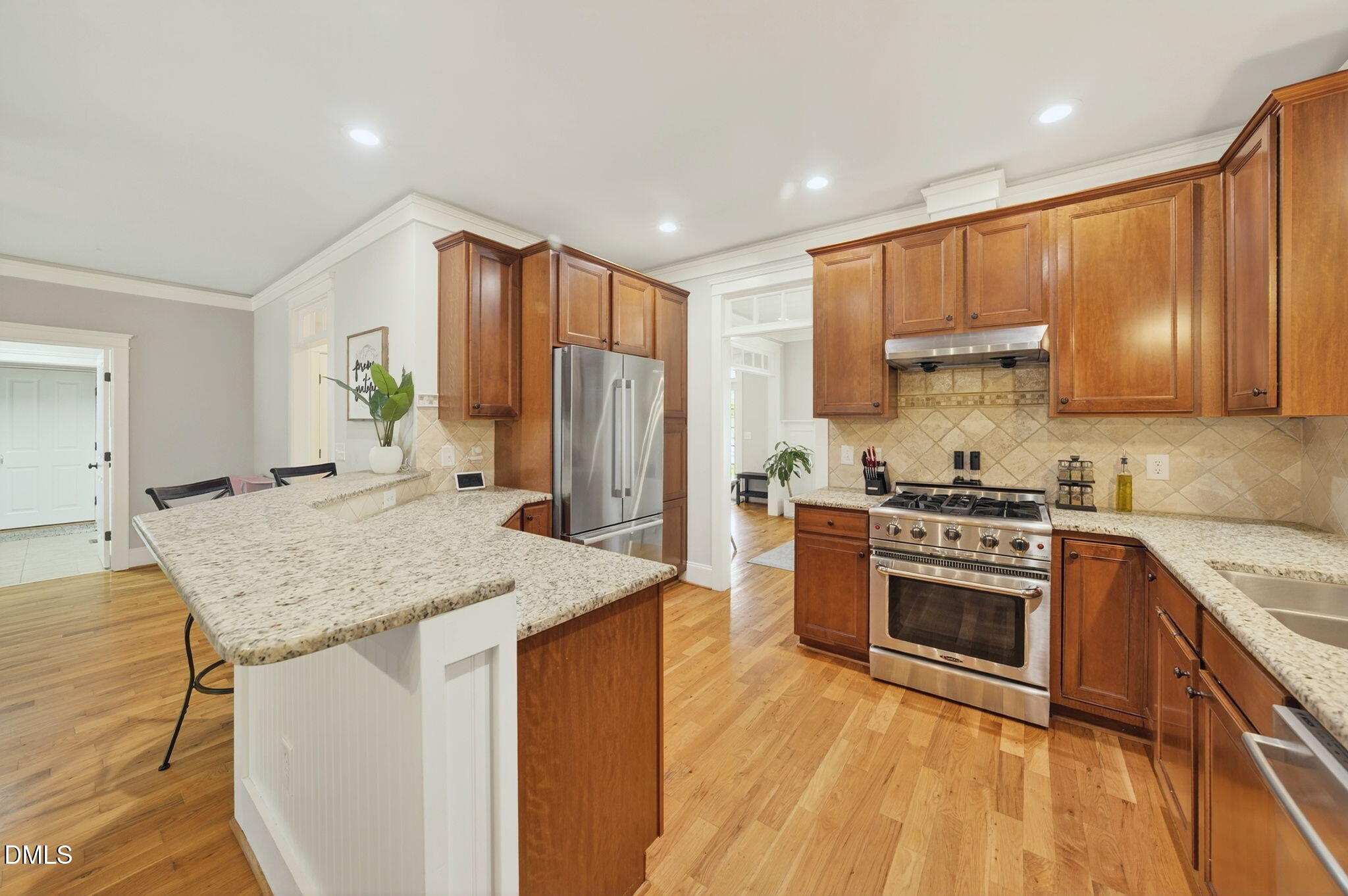 4305 Windscape Drive Apex, NC 27539 - Photo 11 of 50 a kitchen with stainless steel appliances granite countertop wooden cabinets a sink and a stove