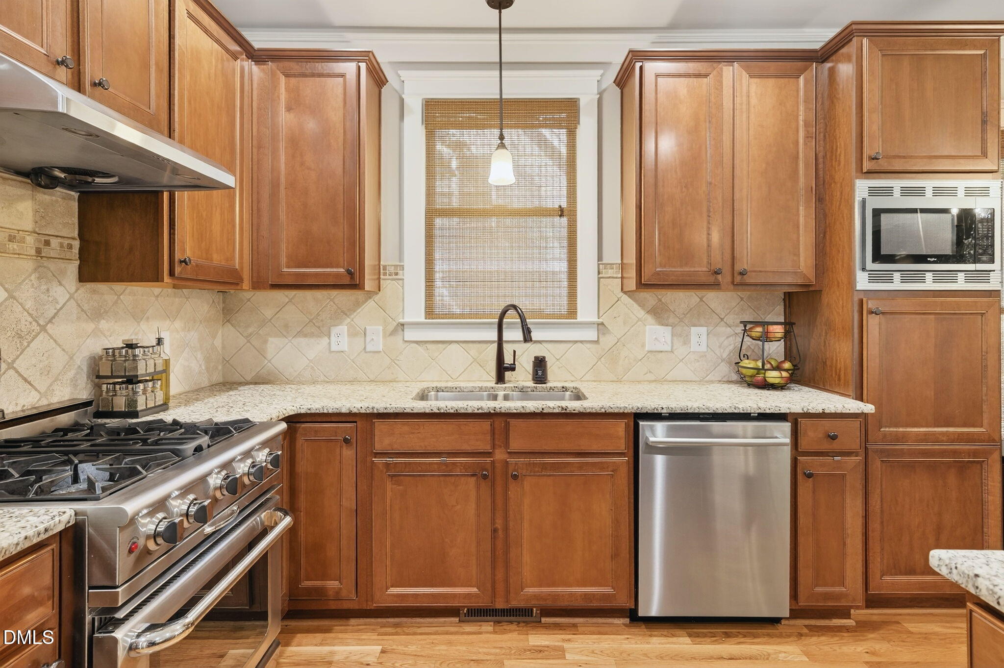 4305 Windscape Drive Apex, NC 27539 - Photo 12 of 50 a kitchen with granite countertop a sink a stove and wooden cabinets