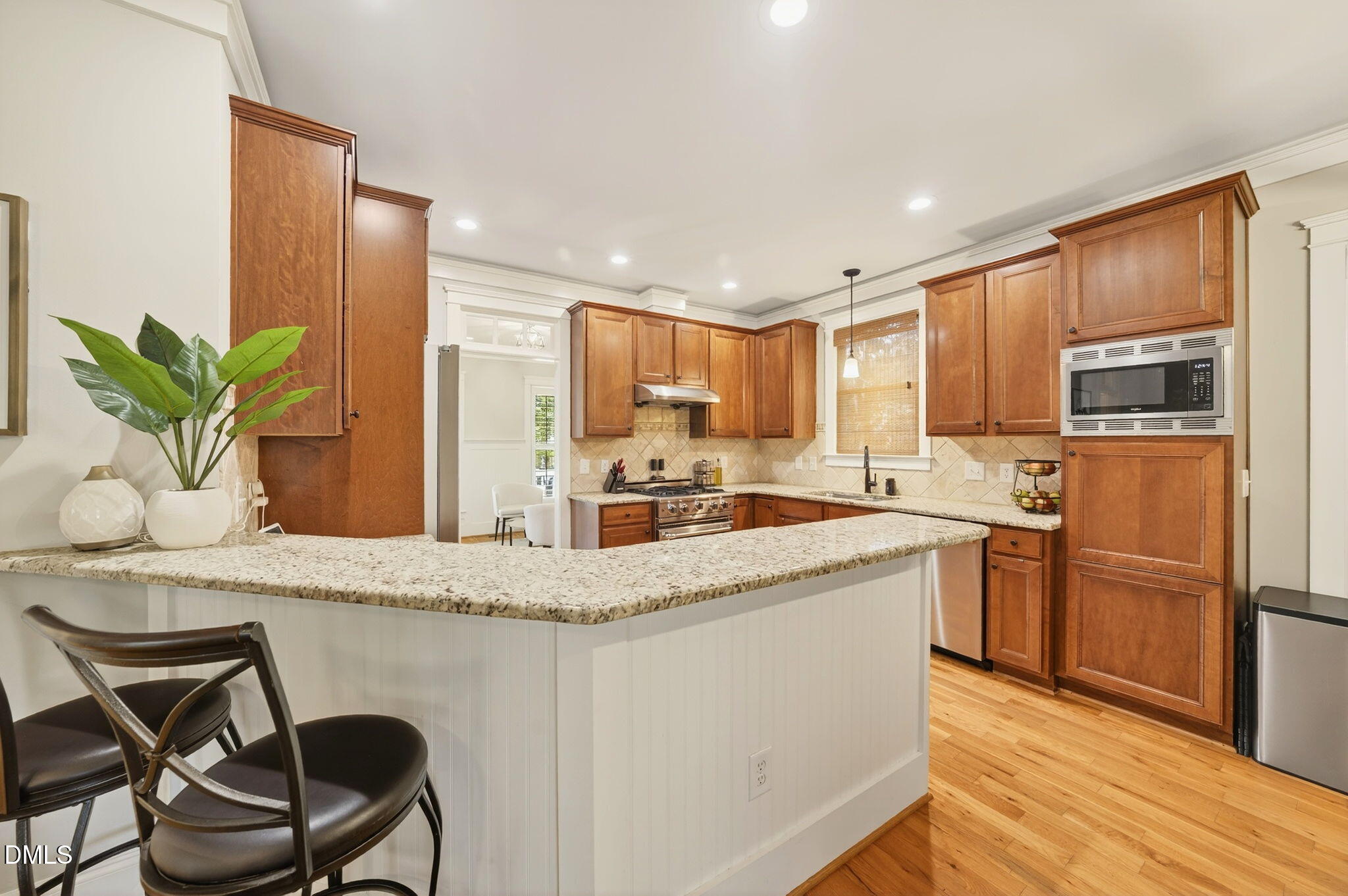 4305 Windscape Drive Apex, NC 27539 - Photo 20 of 50 a kitchen with stainless steel appliances granite countertop a refrigerator a stove top oven a sink with island and chairs
