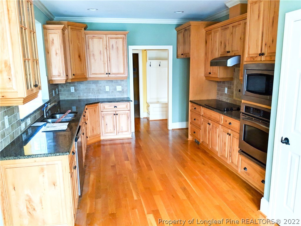 238 Falling Water Road Spring Lake, NC 28390 - Photo 6 of 7 a kitchen with stainless steel appliances granite countertop a stove a sink and a refrigerator