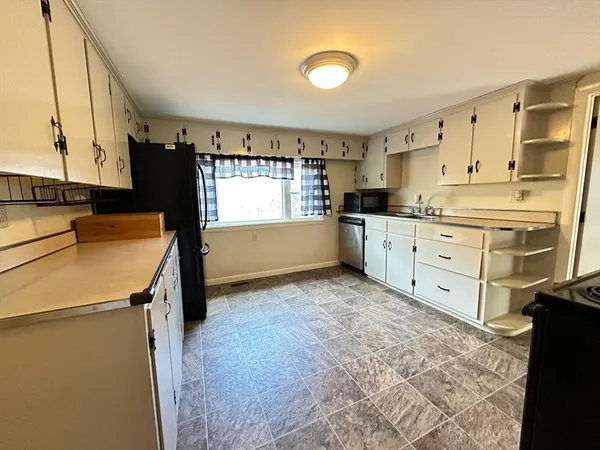 a kitchen with granite countertop a sink stove and refrigerator