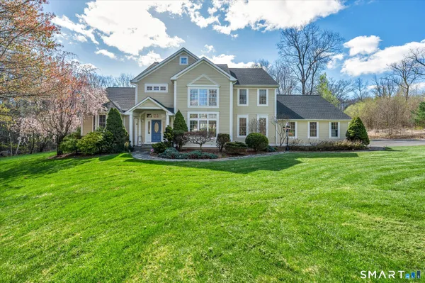 a front view of a house with a yard and trees