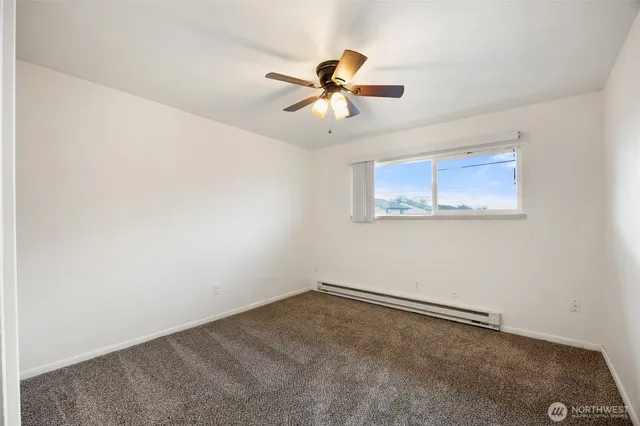 an empty room with closet and a chandelier fan