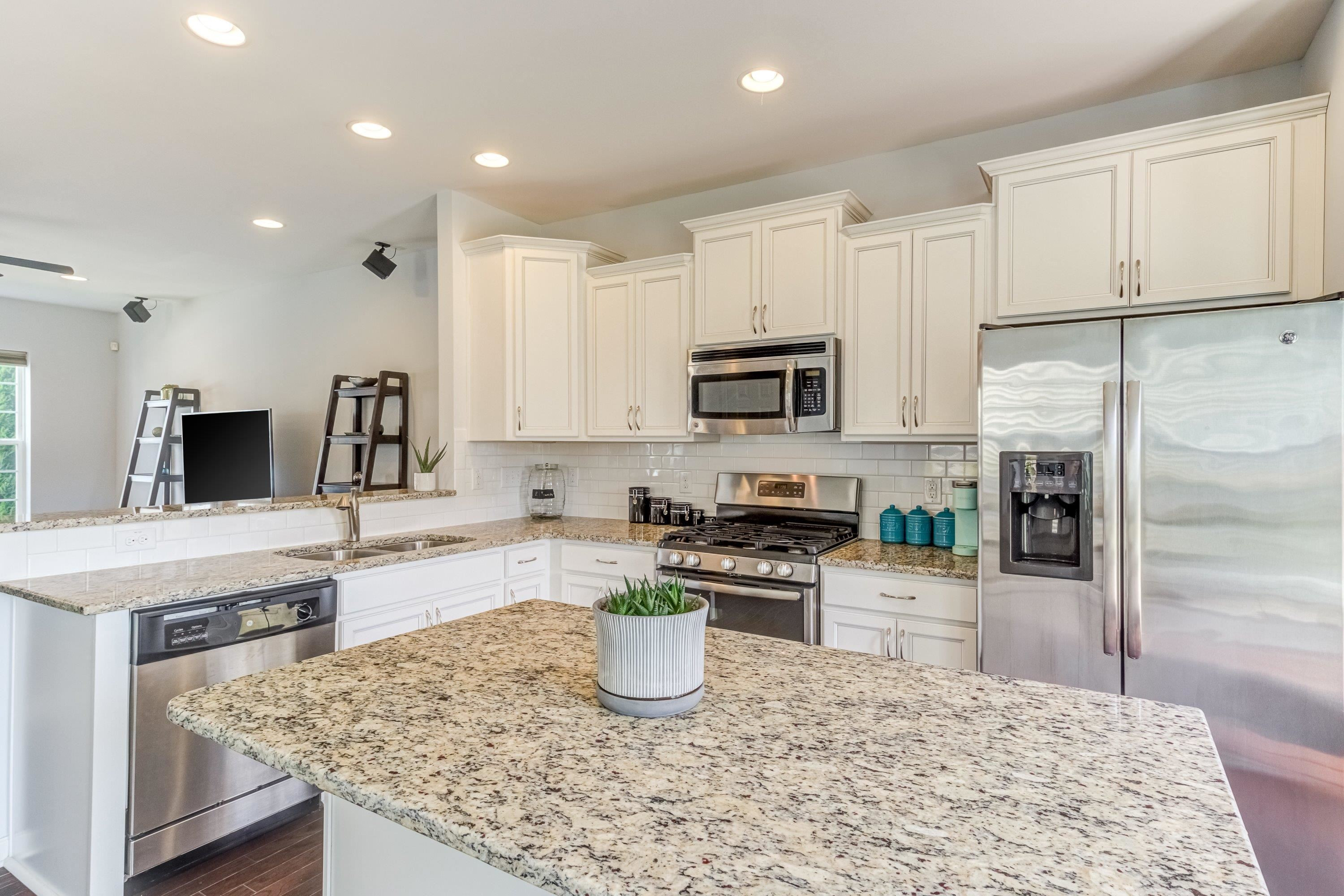 411 Provincial Street Raleigh, NC 27603 - Photo 12 of 41 a kitchen with kitchen island granite countertop a stove sink and microwave