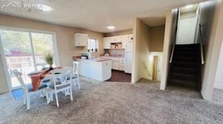 962 Candlestar Loop North Fountain, CO 80817 - Photo 4 of 10 Unfurnished dining area featuring a textured ceiling and dark carpet