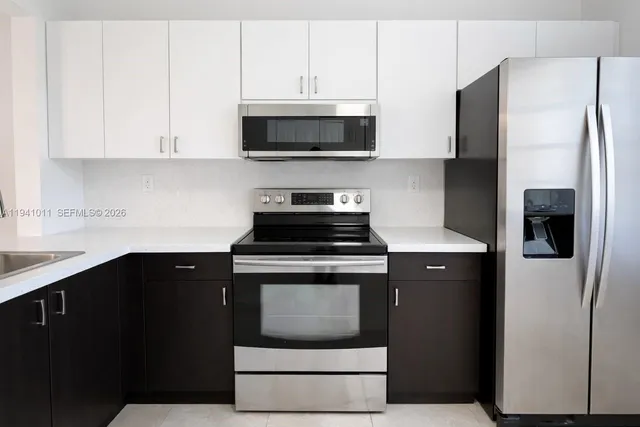 a kitchen with stainless steel appliances a stove a microwave and a refrigerator