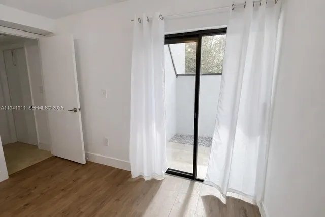 an empty room with wooden floor and door