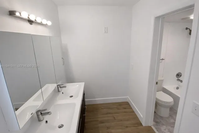 a bathroom with a sink and mirror with toilet