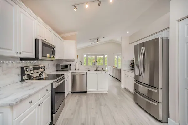 a kitchen with white cabinets and stainless steel appliances