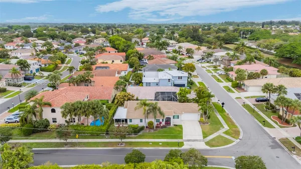 an aerial view of residential houses with outdoor space and trees