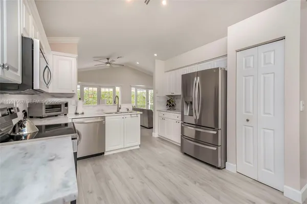 a kitchen with a refrigerator stove and white cabinets