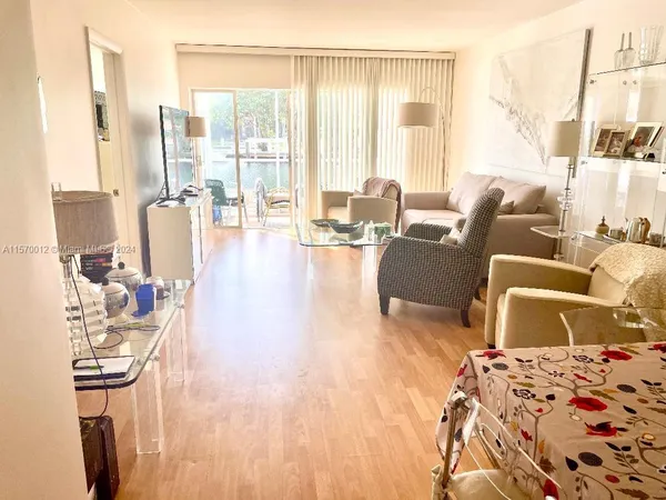 a living room with furniture large window and wooden floor