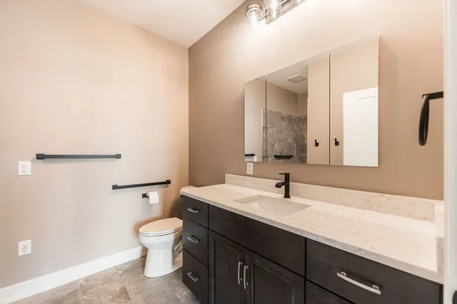 a bathroom with a sink a toilet and mirror