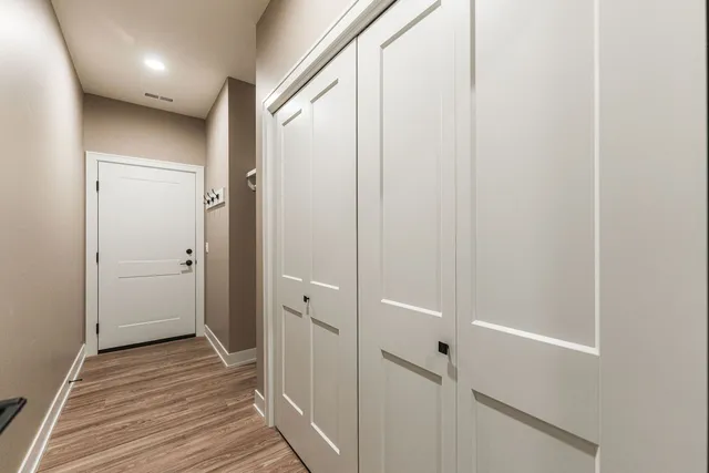 a view of a hallway with wooden floor