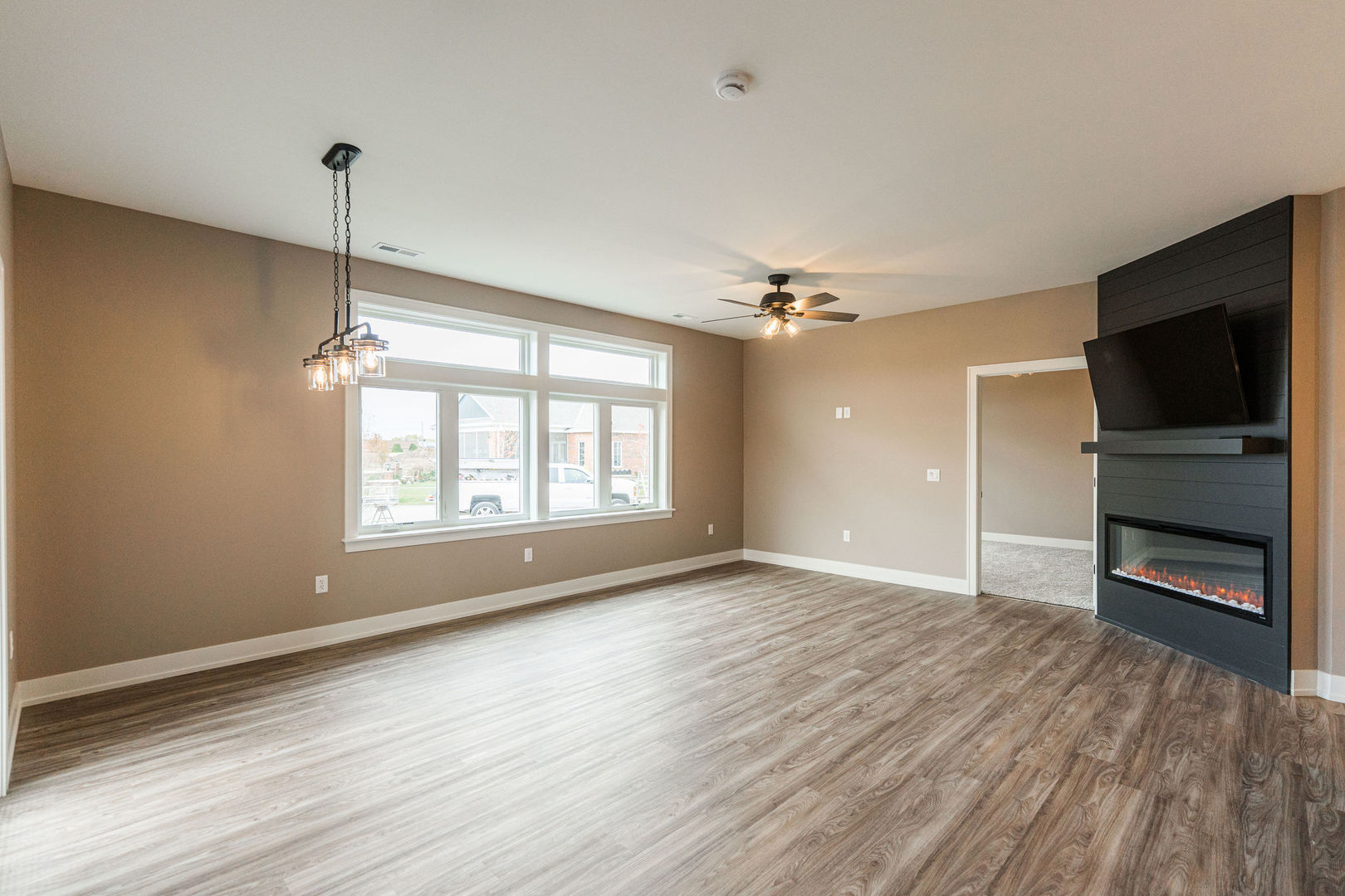 563 Stearn Drive, Unit 563 Genoa, IL 60135 - Photo 7 of 50 an empty room with wooden floor cabinet and windows