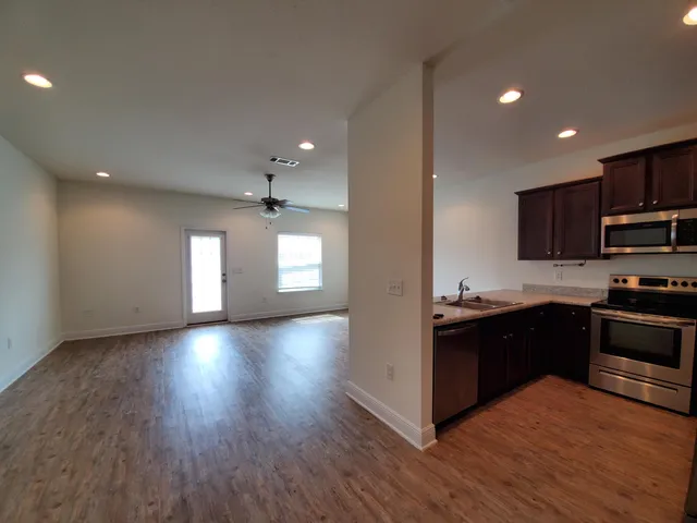 a kitchen with granite countertop a stove top oven and cabinets