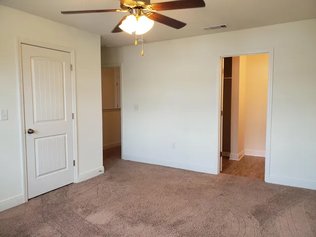 an empty room with a fan and a fan