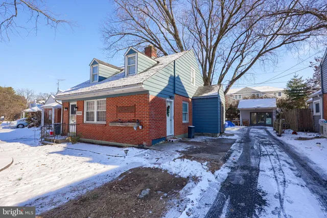 a front view of a house with a yard covered in snow