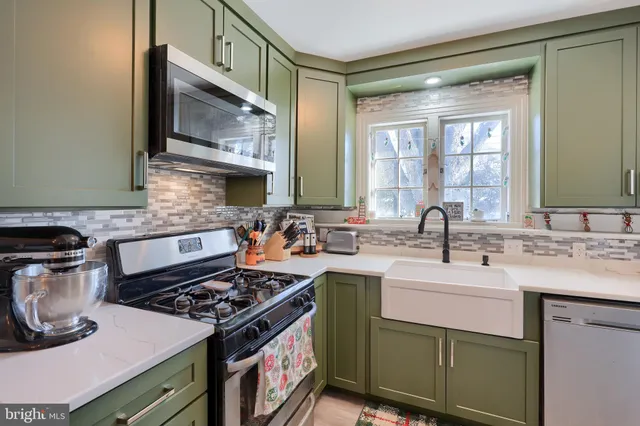 a kitchen with stainless steel appliances a sink stove and cabinets