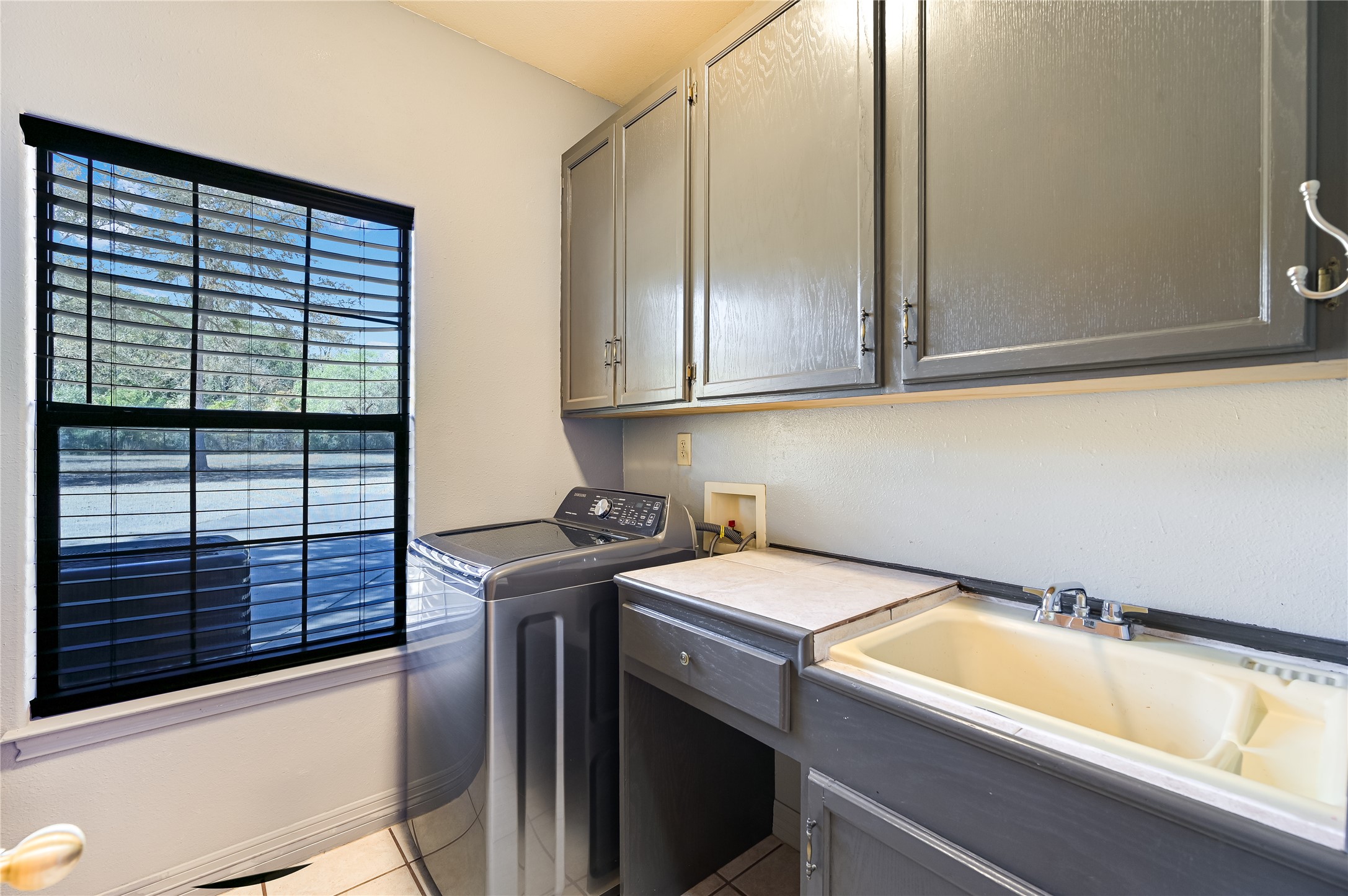 486 Westwood Road Lockhart, TX 78644 - Photo 12 of 29 Washroom with light tile flooring, cabinet space, and washer and dryer space with a sink