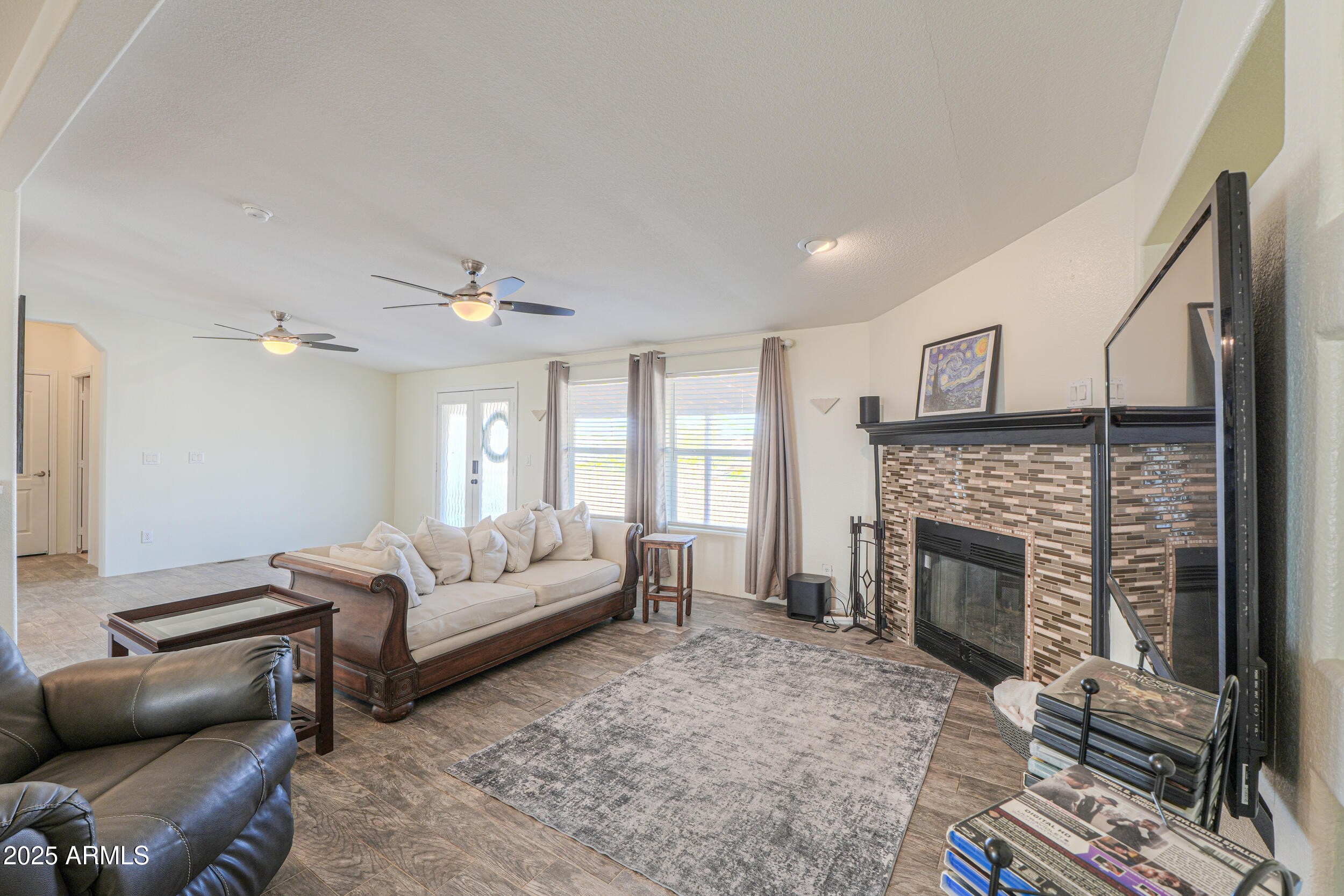 176 North Acacia Road Apache Junction, AZ 85119 - Photo 17 of 65 a living room with furniture a fireplace and a flat screen tv