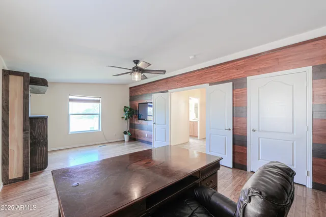a front view of a house with a dirt yard and parking space