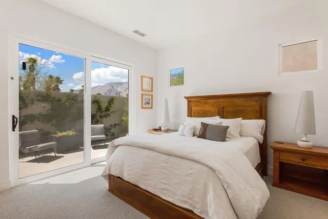a bedroom with a bed and a large window