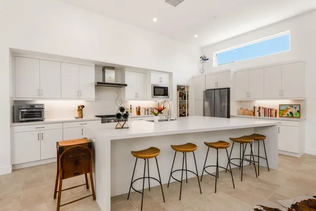 a kitchen with stainless steel appliances a table chairs and a refrigerator