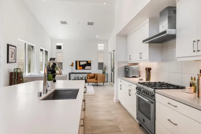 a kitchen with stainless steel appliances a stove a sink a refrigerator and cabinets