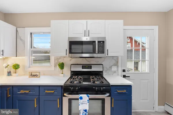 a kitchen with stainless steel appliances a stove a sink and a microwave