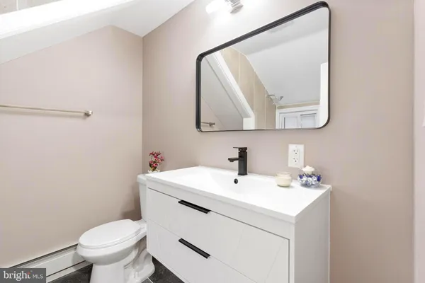 a bathroom with a toilet sink and mirror