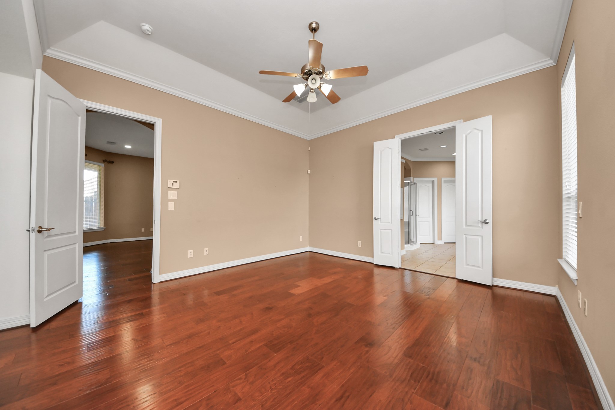 17618 Raven Canyon Lane Houston, TX 77095 - Photo 20 of 45 Spacious primary suite with hardwood floors, high ceilings, and direct access to the en-suite bath.