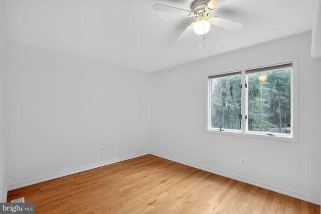 an empty room with a window and a fan