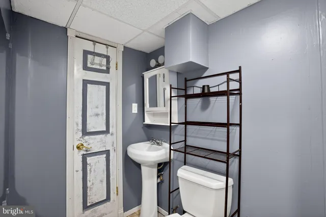 a bathroom with a toilet a sink and mirror