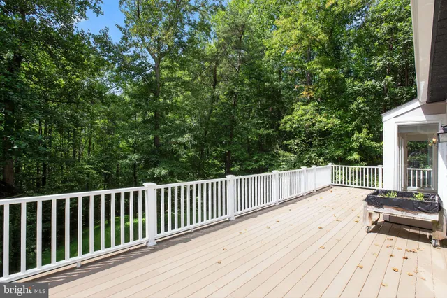 a balcony with wooden floor and trees in the background