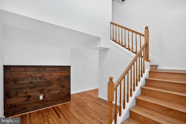 a view of a hallway with wooden floor and staircase