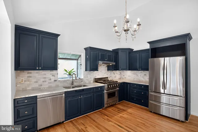 a kitchen with stainless steel appliances granite countertop wooden cabinets a refrigerator sink and dishwasher