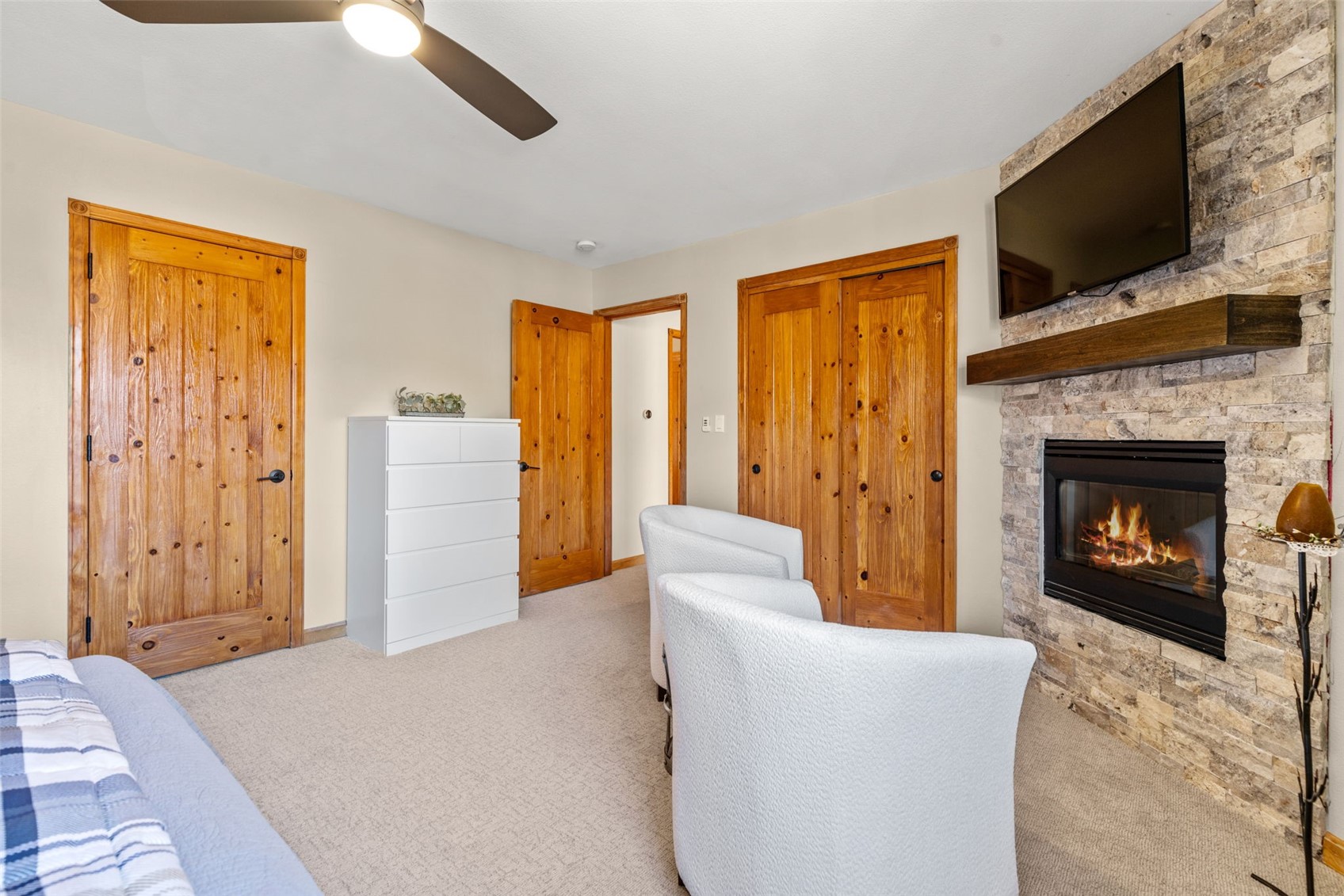 142 Lookout Ridge Drive Dillon, CO 80435 - Photo 25 of 39 Bedroom featuring ceiling fan, a stone fireplace, and light colored carpet