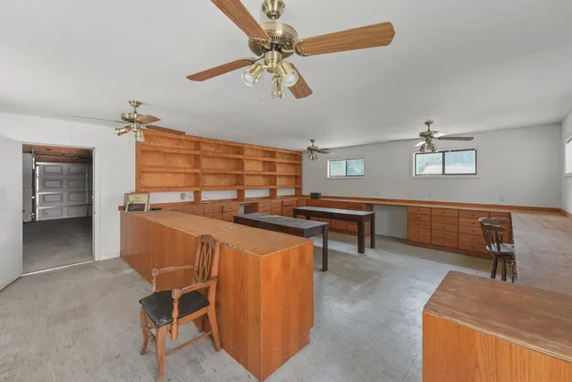 a dining hall with stainless steel appliances kitchen island granite countertop furniture and a chandelier