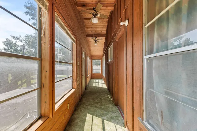 a view of hallway with wooden floor and door