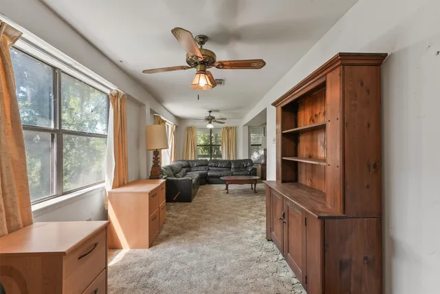 a living room with furniture a window and a ceiling fan