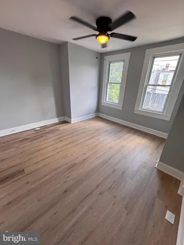an empty room with windows and wooden floor