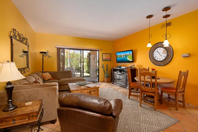 a living room with furniture a large window and a clock