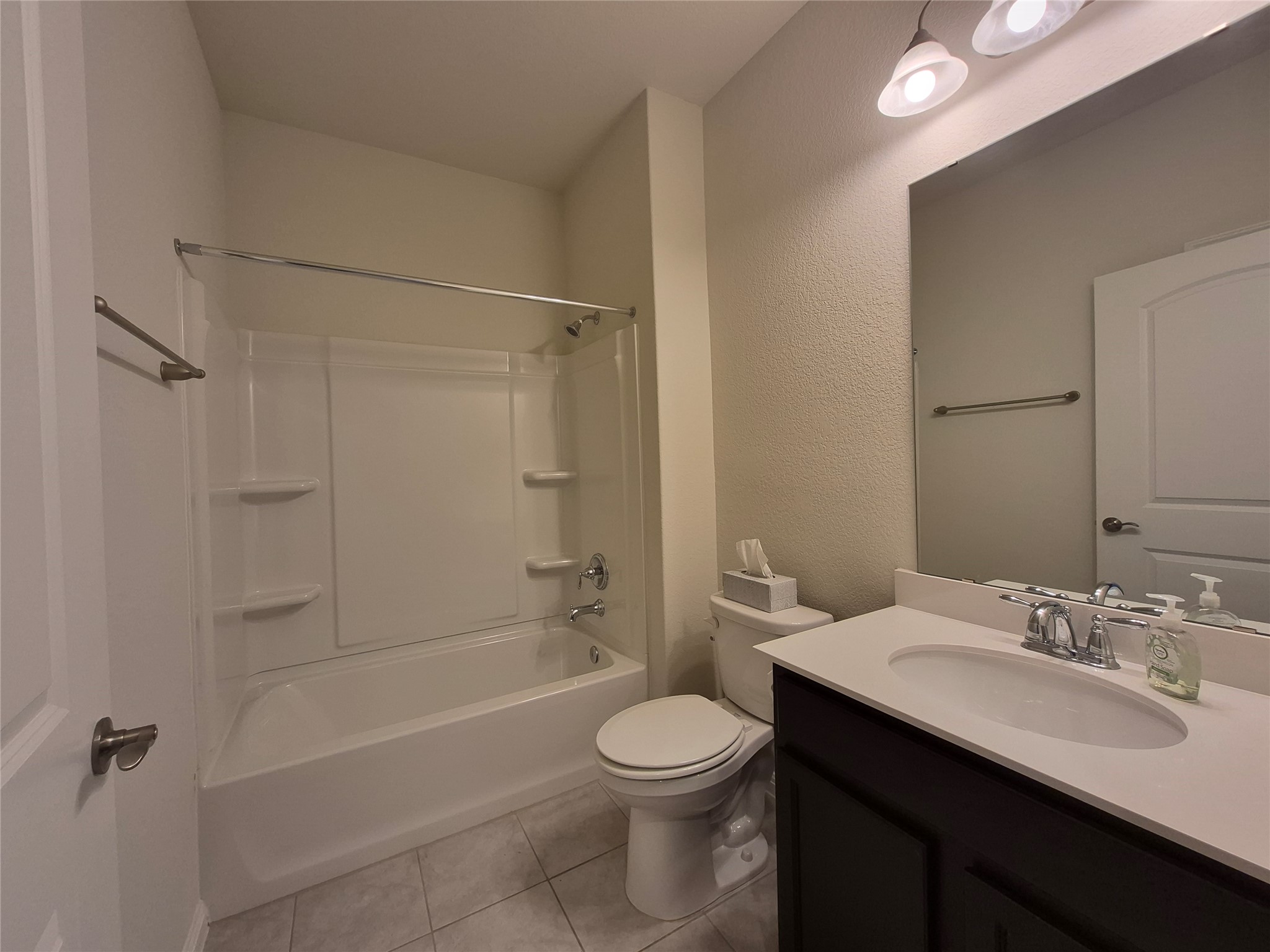 108 Calhoun Lane Georgetown, TX 78633 - Photo 12 of 27 Bathroom with a textured wall, vanity, shower / bathtub combination, and light tile patterned floors