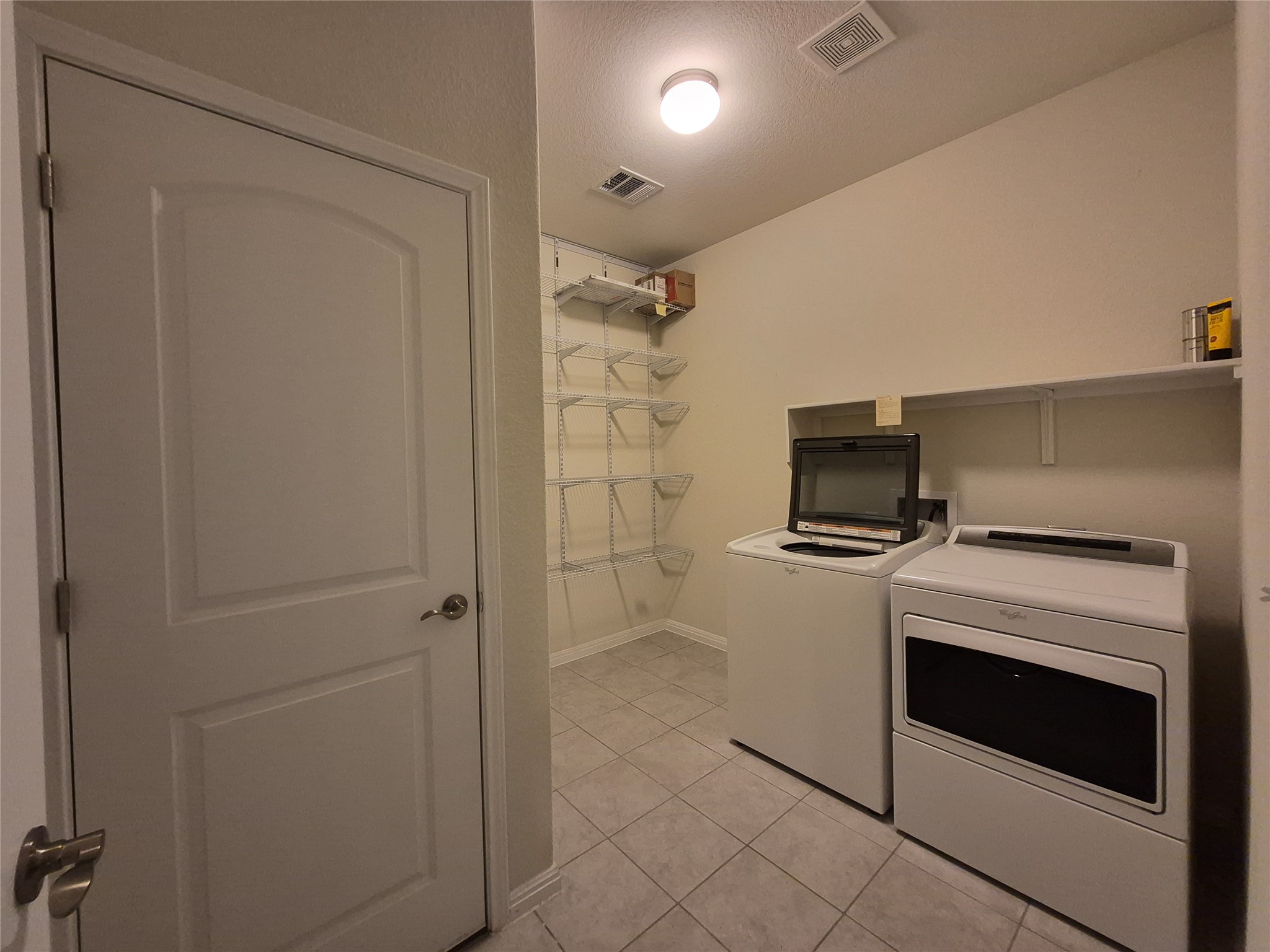 108 Calhoun Lane Georgetown, TX 78633 - Photo 17 of 27 Laundry room with independent washer and dryer, light tile patterned floors, and a textured ceiling