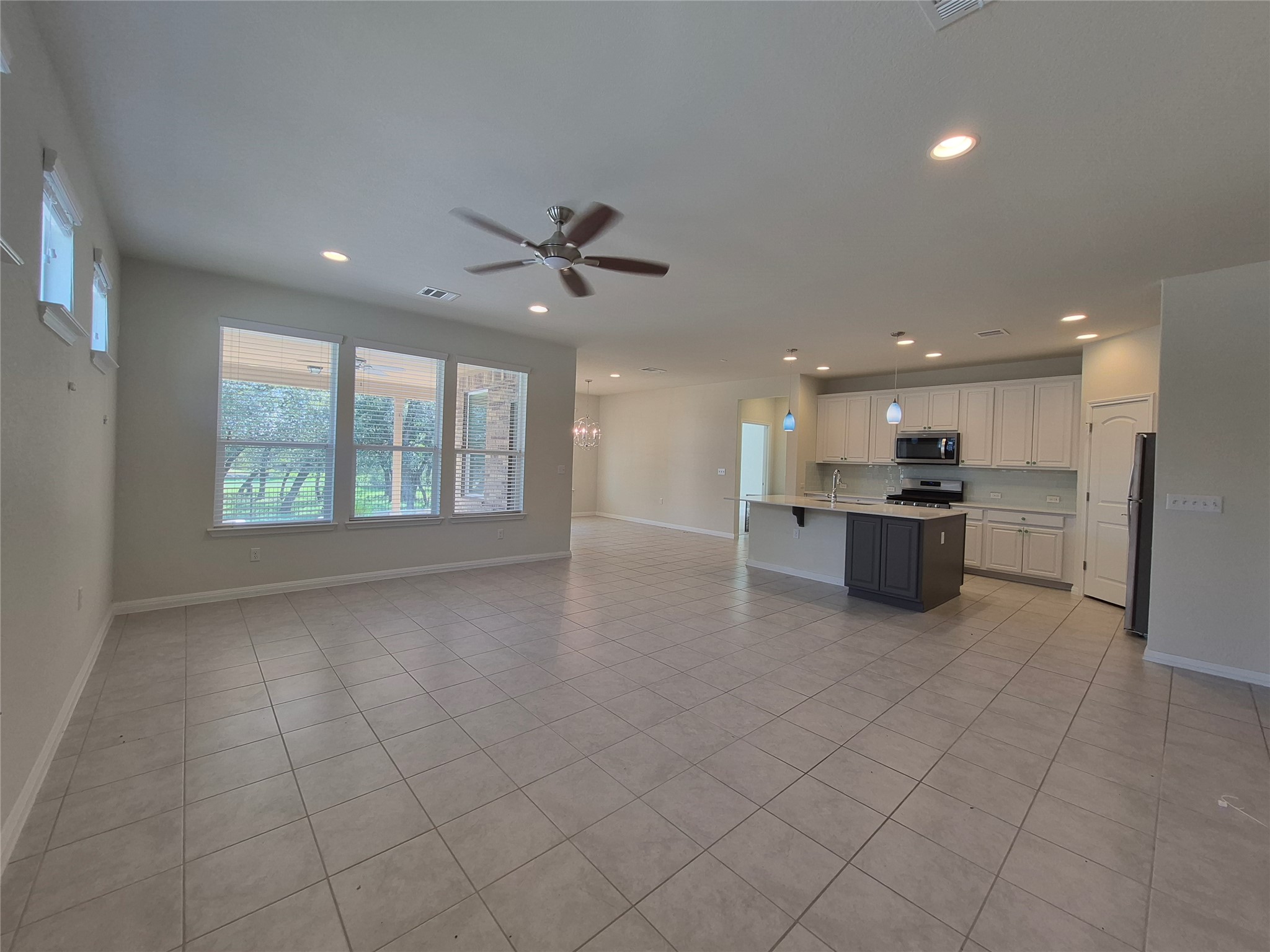 108 Calhoun Lane Georgetown, TX 78633 - Photo 26 of 27 Dual tone kitchen featuring open floor plan, a ceiling fan, hanging light fixtures, light tile patterned floors, and stainless steel appliances