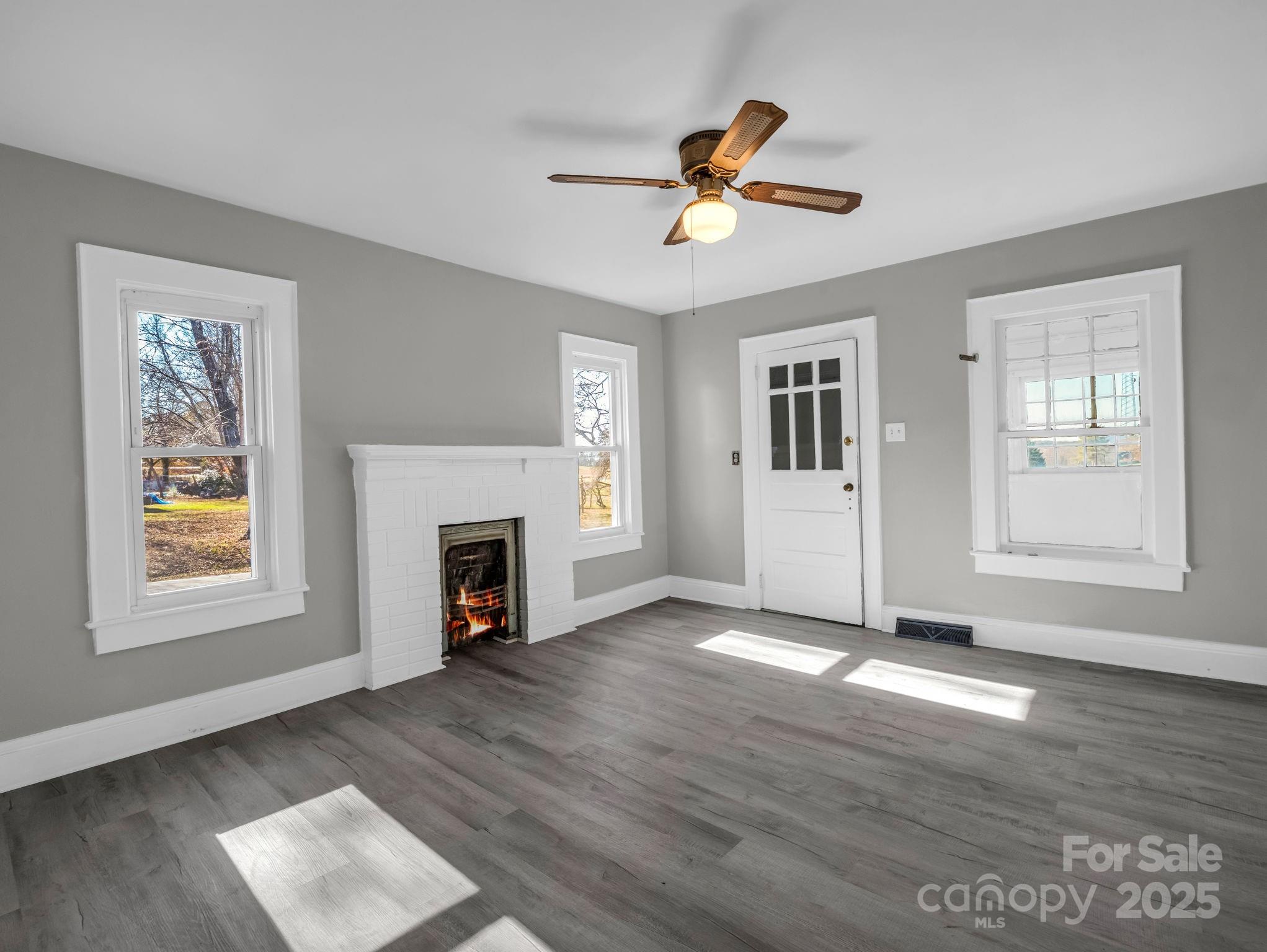 4501 Polkville Road Shelby, NC 28150 - Photo 12 of 35 a view of a livingroom with a fireplace a ceiling fan and windows