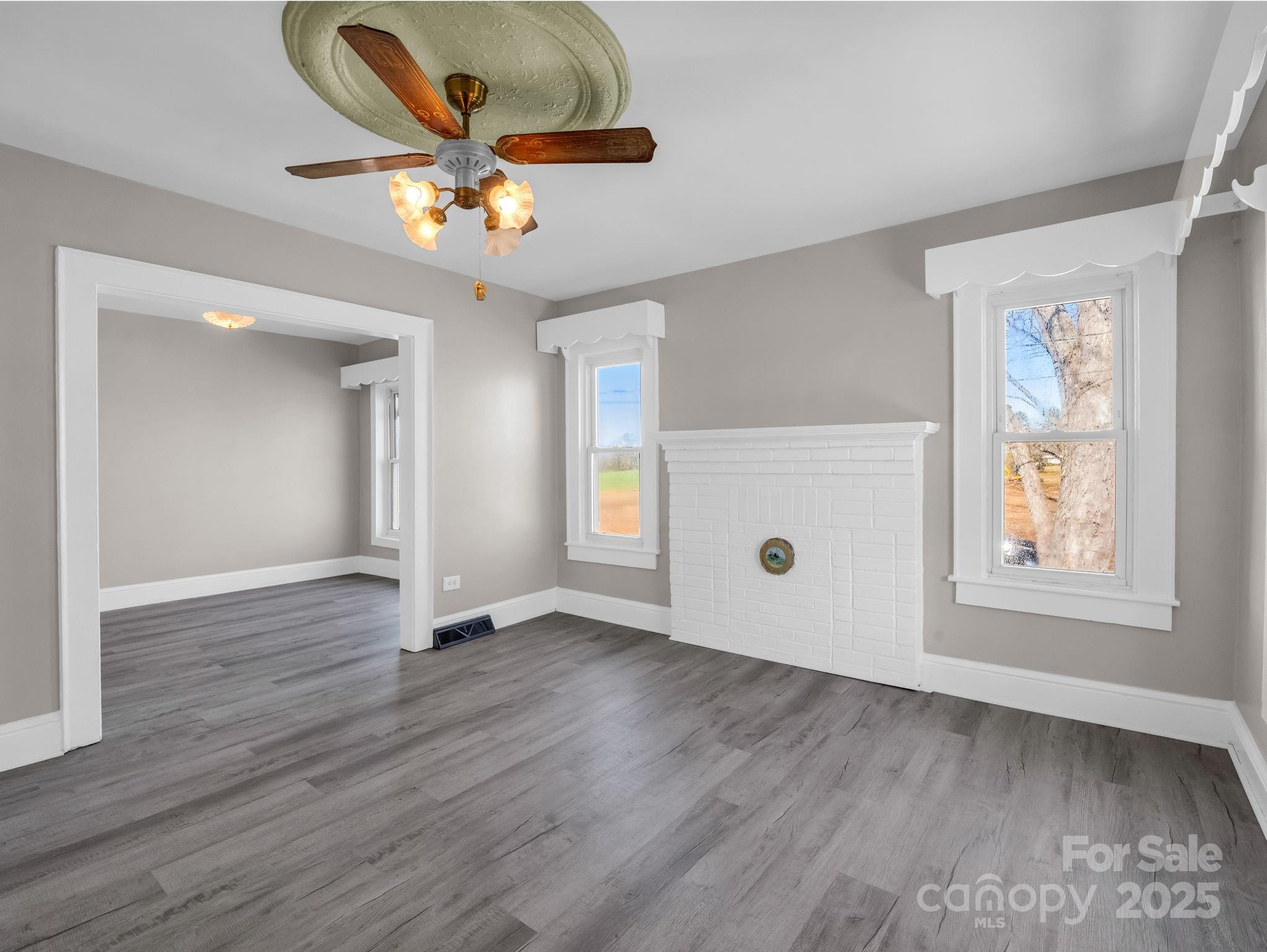 4501 Polkville Road Shelby, NC 28150 - Photo 16 of 35 an empty room with wooden floor chandelier fan and windows