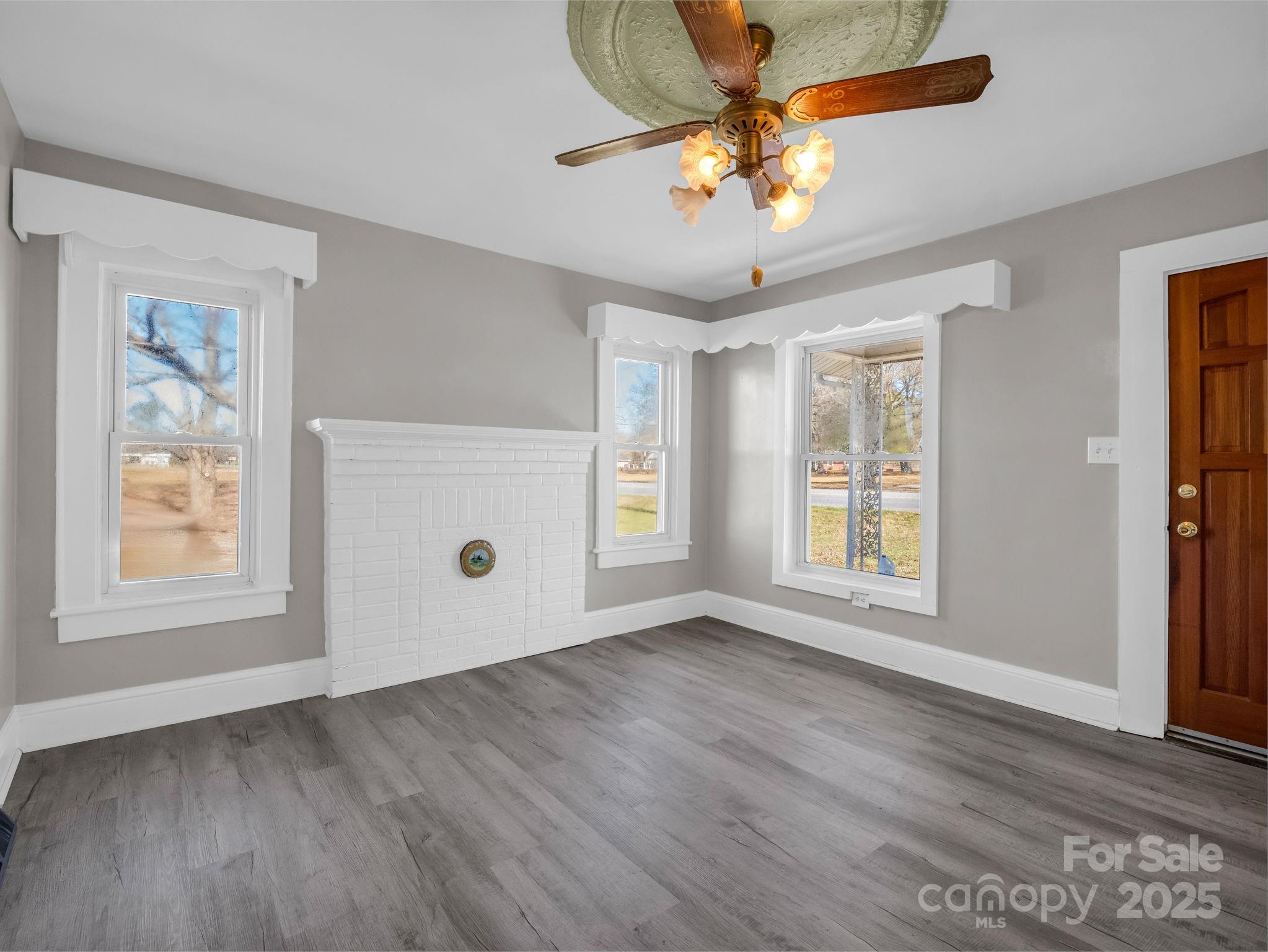 4501 Polkville Road Shelby, NC 28150 - Photo 4 of 35 an empty room with wooden floor chandelier fan and windows